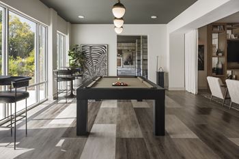 A pool table is in the middle of a room with a zebra print on the wall.